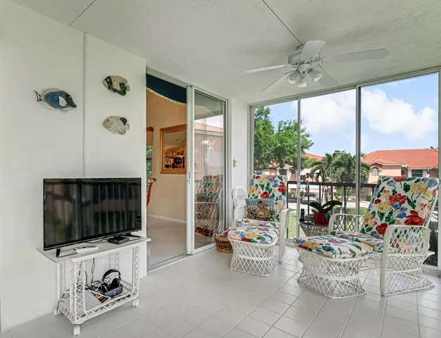 a living room with furniture a flat screen tv and a large window