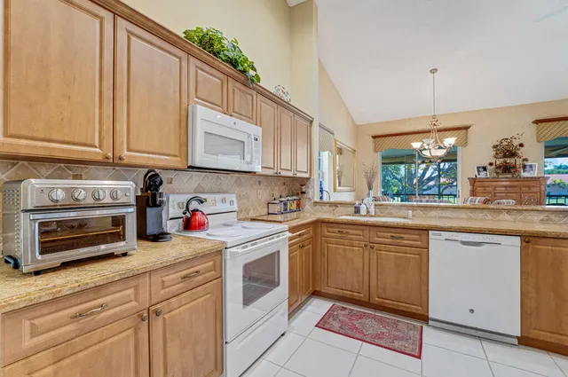 a kitchen with granite countertop a sink stainless steel appliances and cabinets
