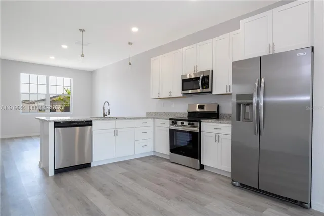 a kitchen with a refrigerator and a stove top oven
