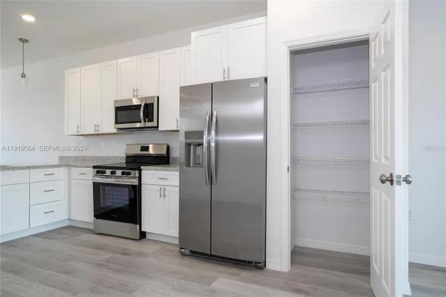 a kitchen with stainless steel appliances cabinets a stove and a refrigerator