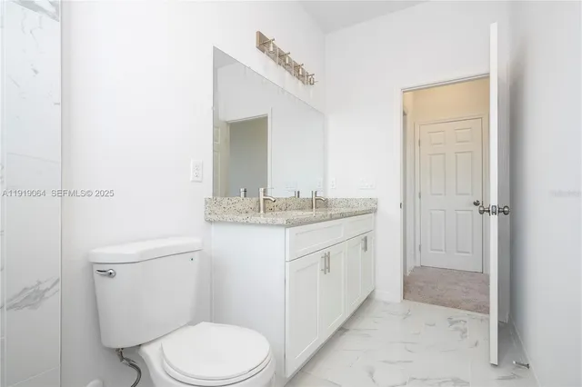 a bathroom with a granite countertop sink toilet and shower