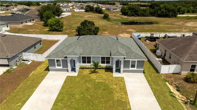 an aerial view of a house with swimming pool and outdoor seating