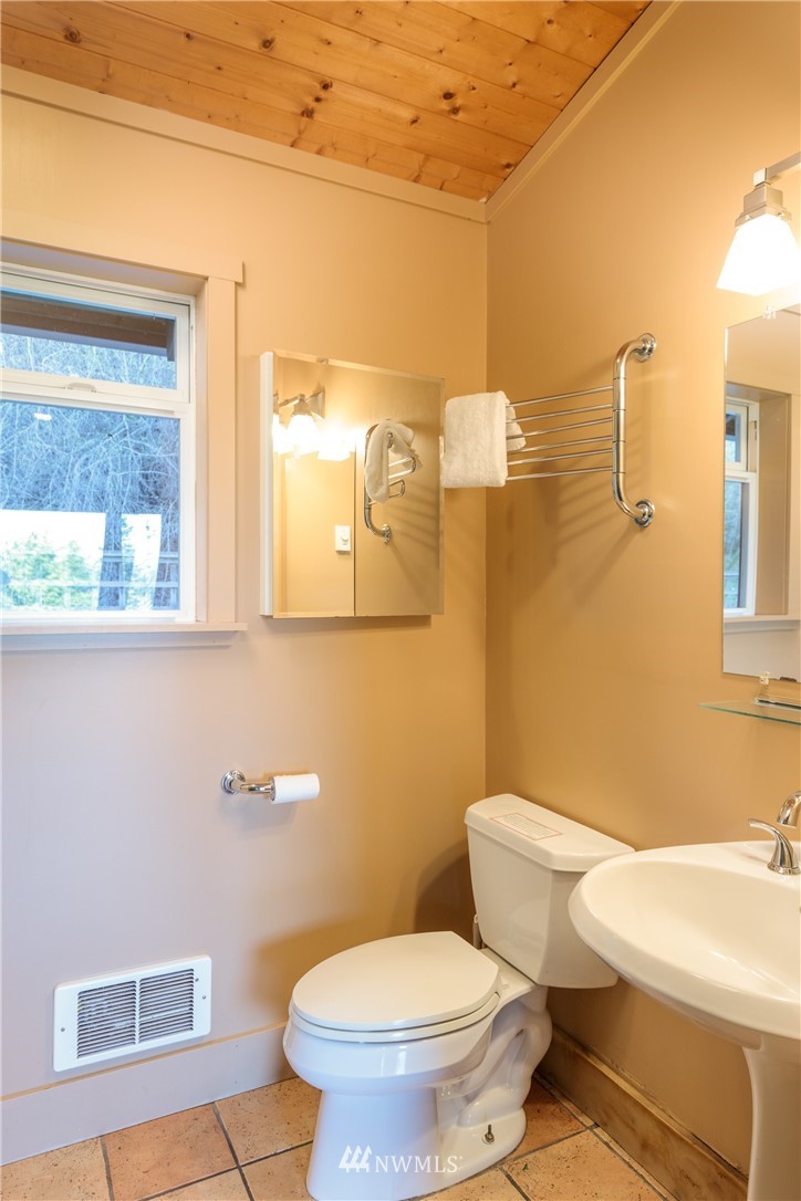 1108 Lopez Sound Road Lopez Island, WA 98261 - Photo 6 of 18 a white toilet sitting next to a bathroom sink and vanity