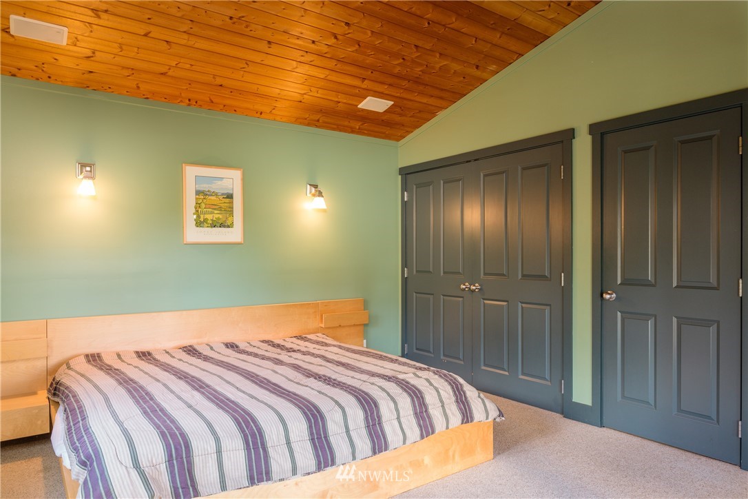 1108 Lopez Sound Road Lopez Island, WA 98261 - Photo 10 of 18 a bedroom with a bed and a chandelier