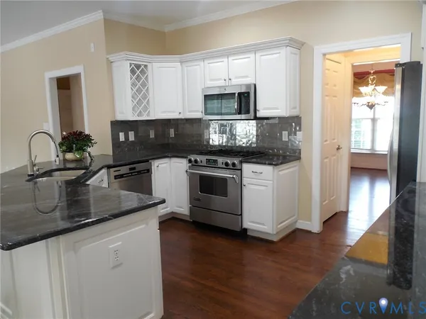 a kitchen with stainless steel appliances granite countertop a sink stove and microwave