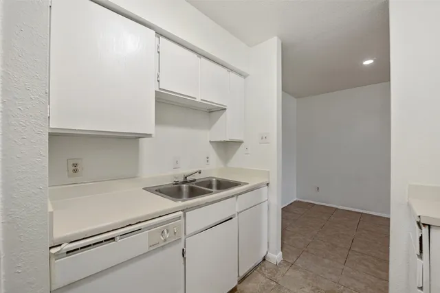 a kitchen with white cabinets and white appliances