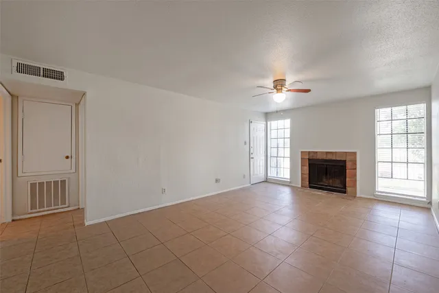 a view of an empty room with a fireplace and a window