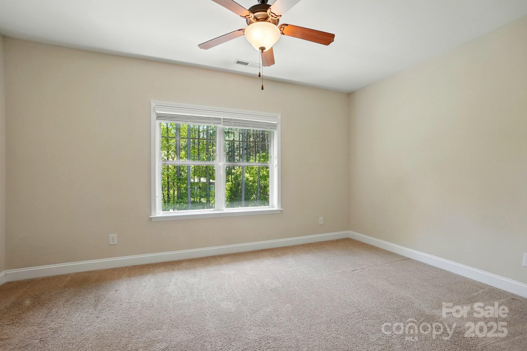 404 Brookridge Drive Mount Holly, NC 28120 - Photo 26 of 44 an empty room with a window and a fan