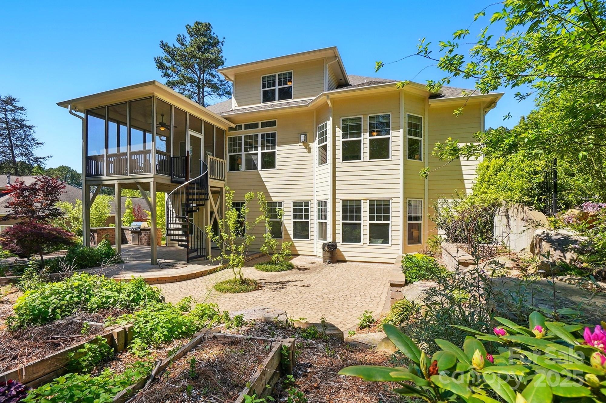 404 Brookridge Drive Mount Holly, NC 28120 - Photo 36 of 44 a view of a white house with large windows and flower plants