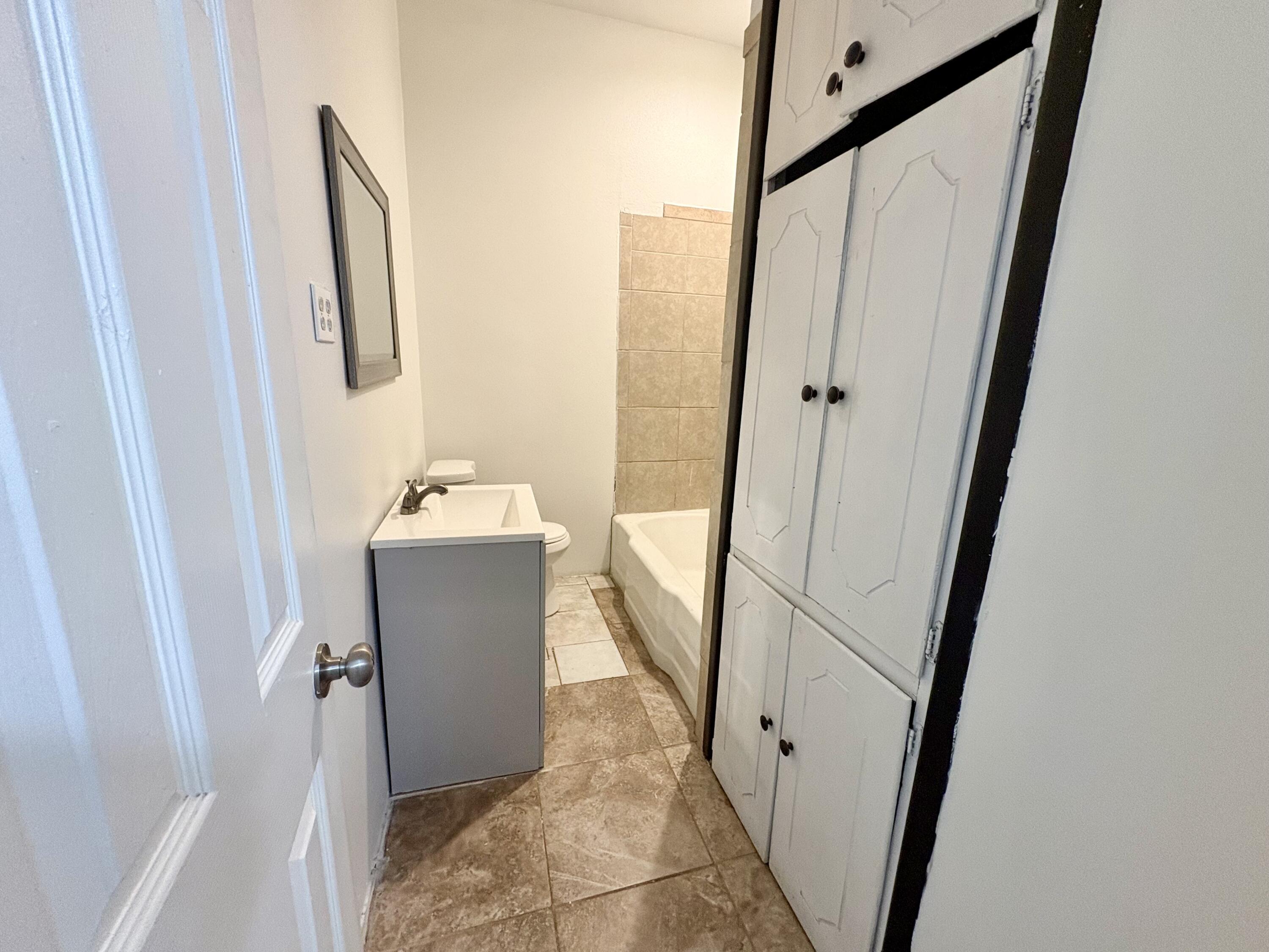4403 44th Street Lubbock, TX 79414 - Photo 14 of 25 a bathroom with a sink and mirror with bathtub