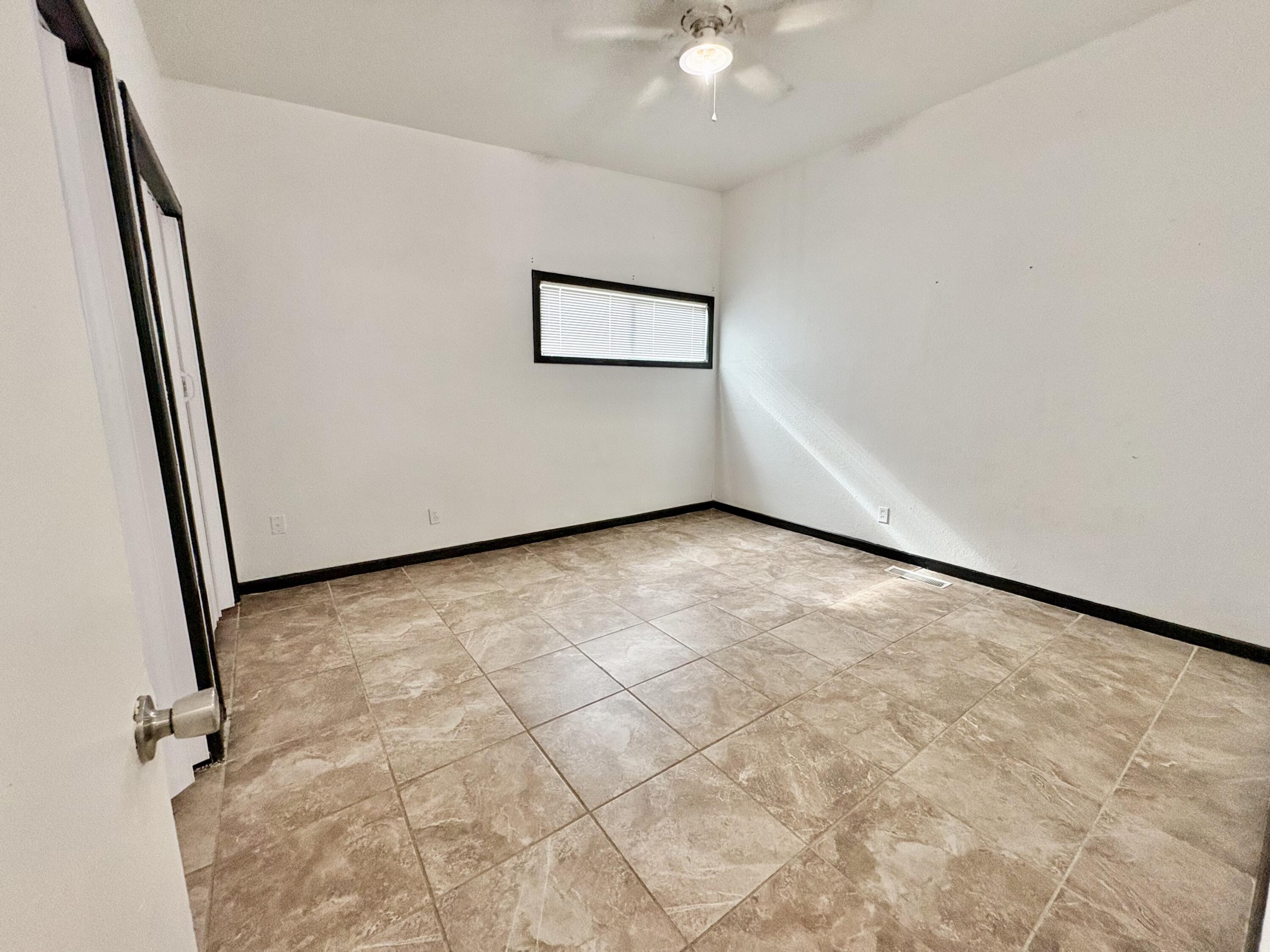 4403 44th Street Lubbock, TX 79414 - Photo 16 of 25 an empty room with a chandelier fan and windows