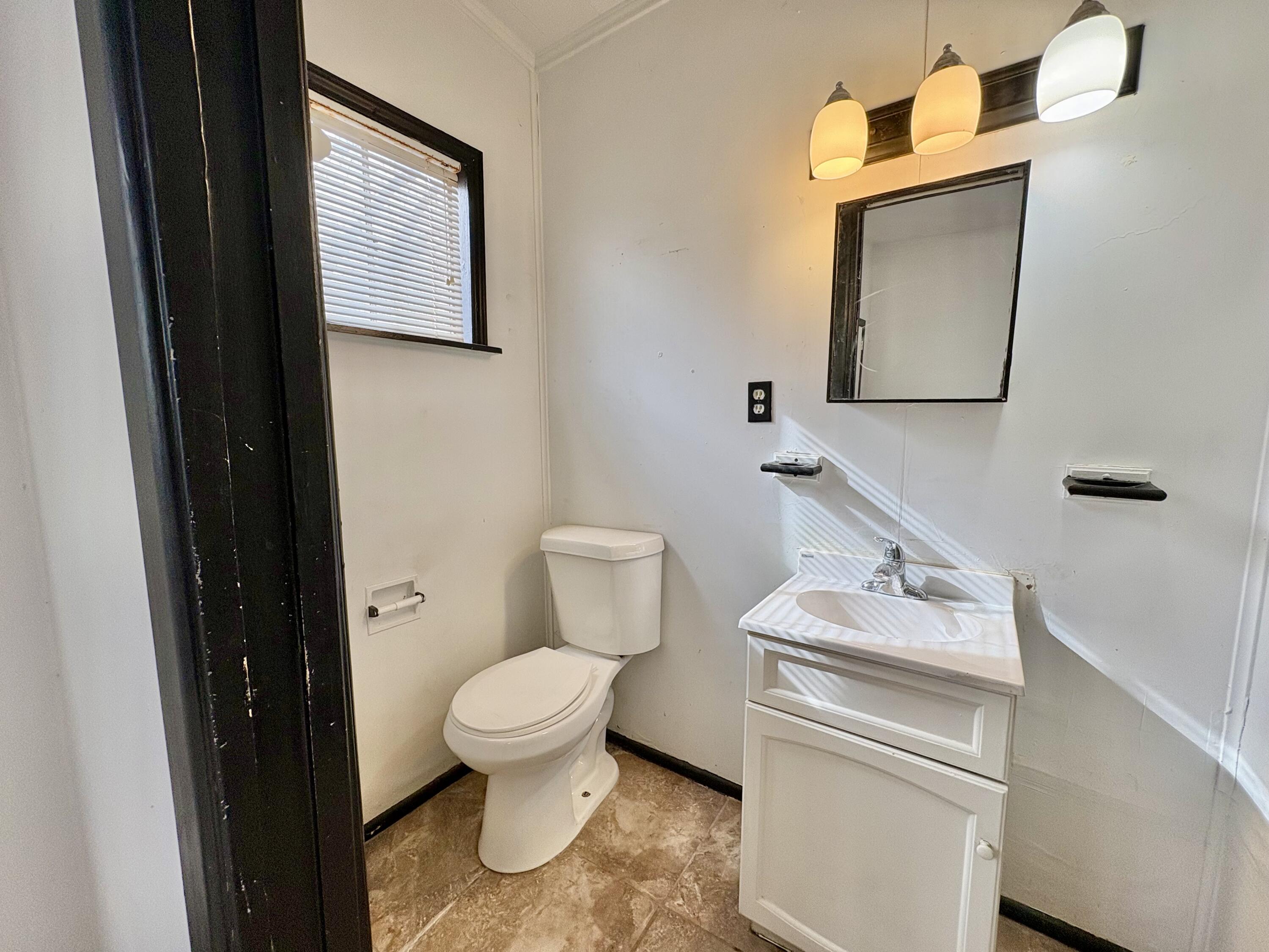 4403 44th Street Lubbock, TX 79414 - Photo 22 of 25 a bathroom with a toilet sink and mirror