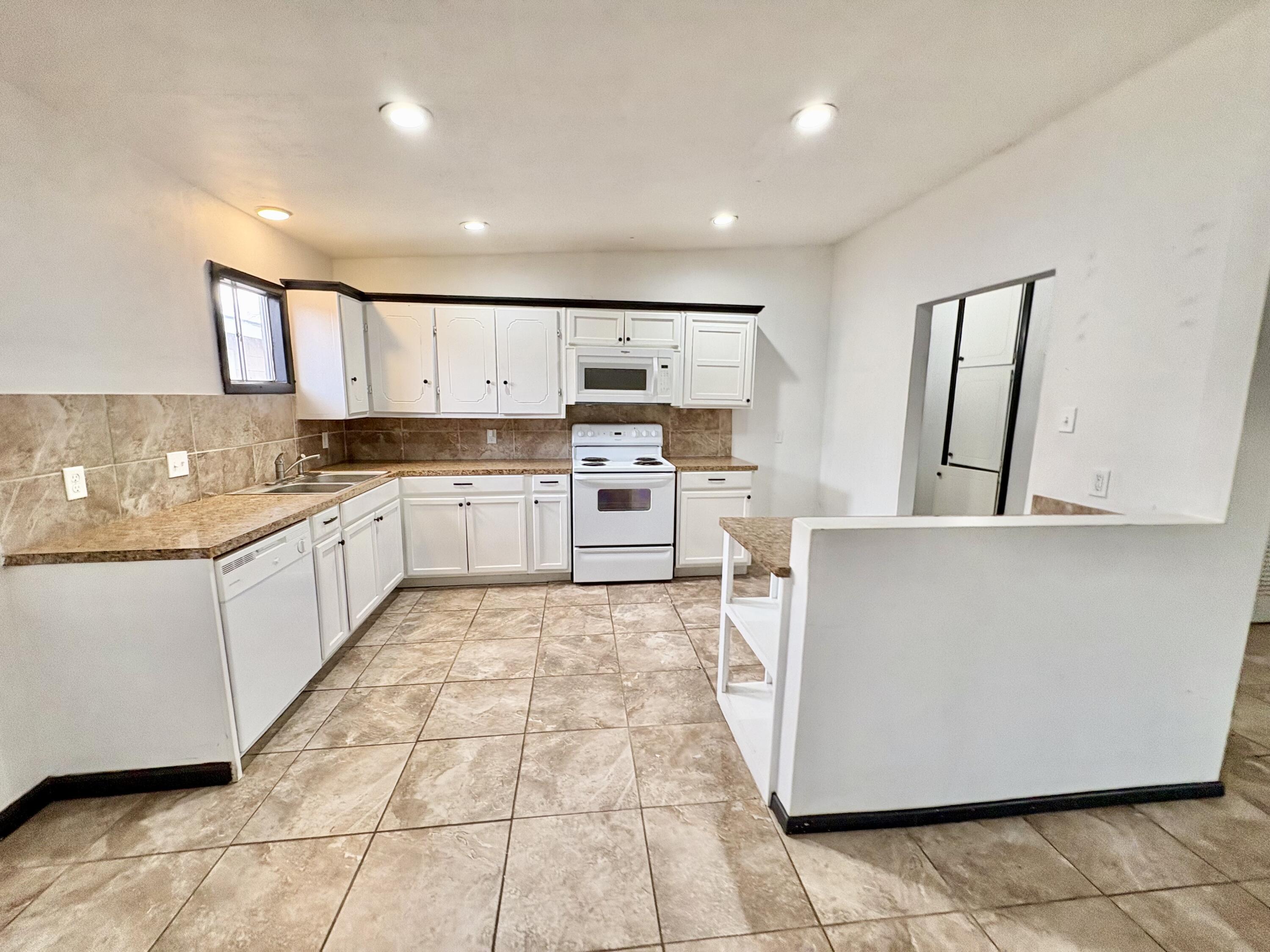 4403 44th Street Lubbock, TX 79414 - Photo 8 of 25 a large kitchen with stainless steel appliances granite countertop a stove a sink and a refrigerator