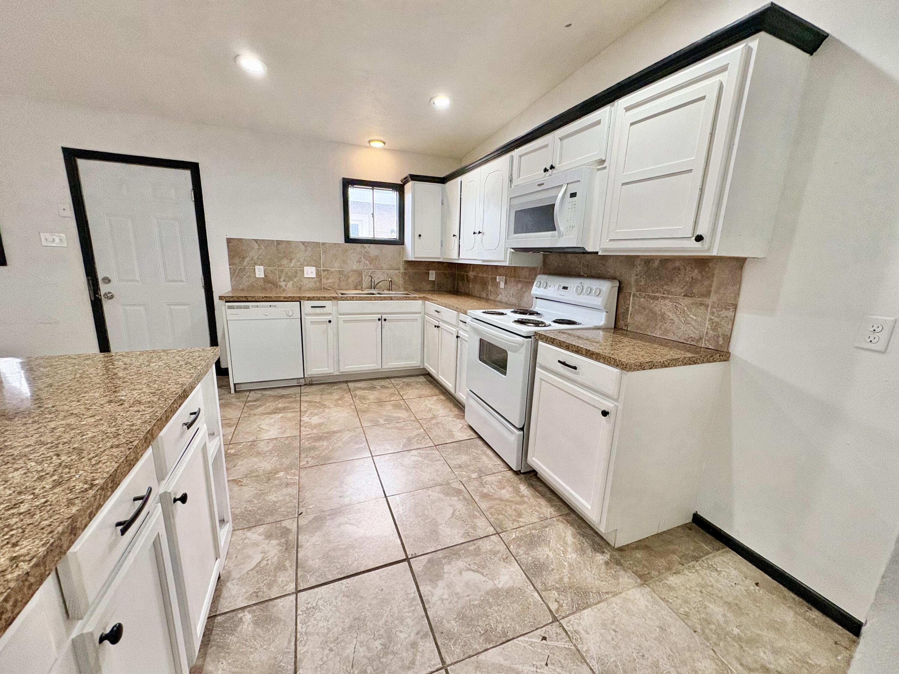 4403 44th Street Lubbock, TX 79414 - Photo 10 of 25 a large kitchen with stainless steel appliances granite countertop a stove a sink and a granite counter tops