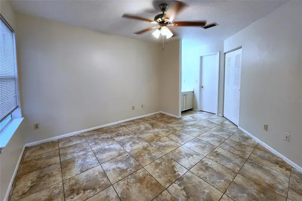 a view of a big room with a ceiling fan and carpet