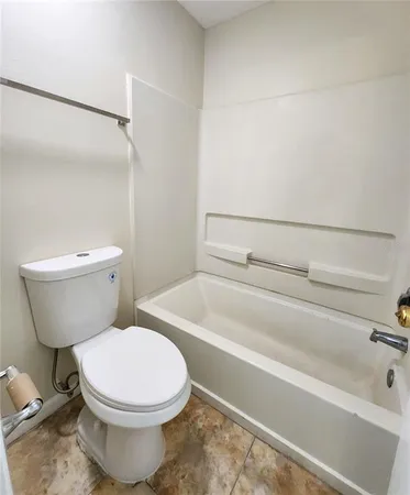 a white toilet sitting next to a bath tub