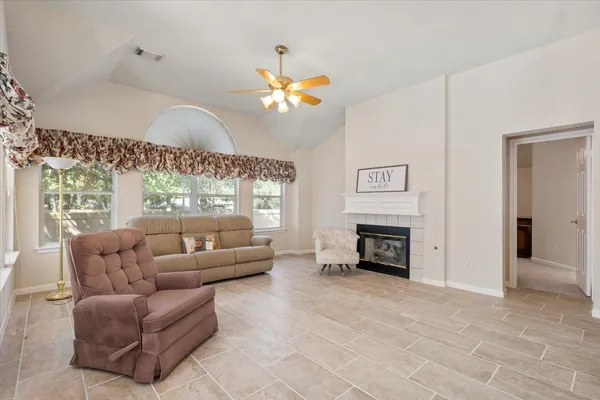 a living room with furniture a fireplace and a flat screen tv
