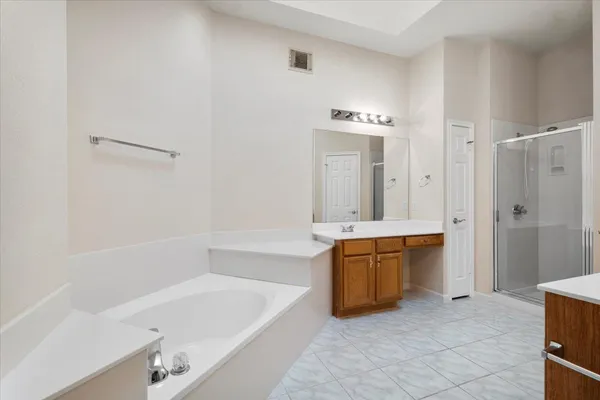 a bathroom with a tub a sink and a large mirror
