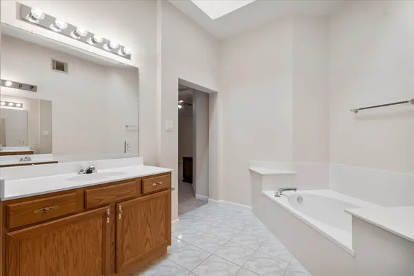 a bathroom with a tub sink and mirror