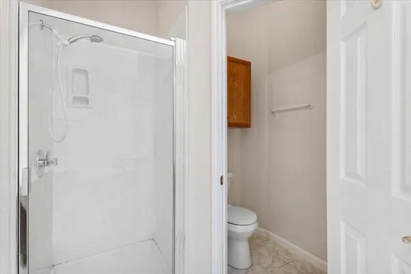 a bathroom with a granite countertop shower and a toilet