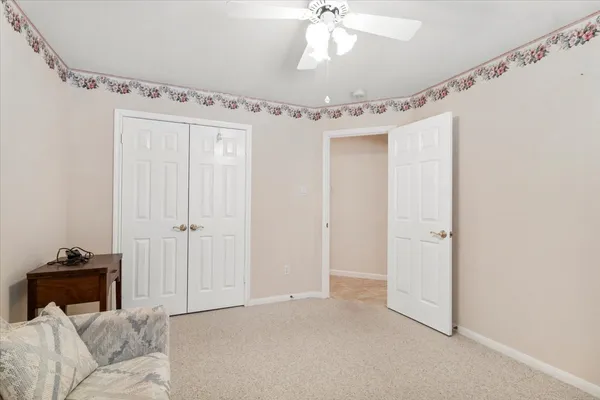 a living room with furniture and a ceiling fan