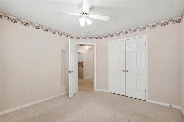 a view of a big room with chandelier fan and closet