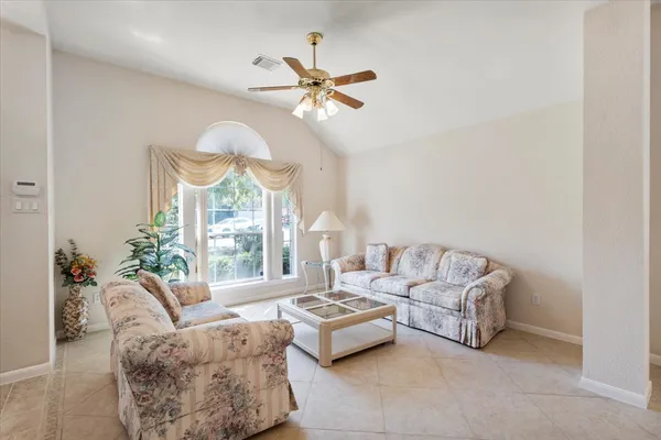 a living room with furniture a chandelier and a large window