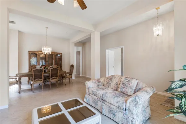 a living room with furniture and a dining table with kitchen view