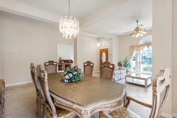 a dining room with furniture a chandelier and window