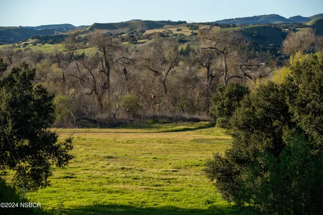 aerial view of a house with outdoor space and a lake view