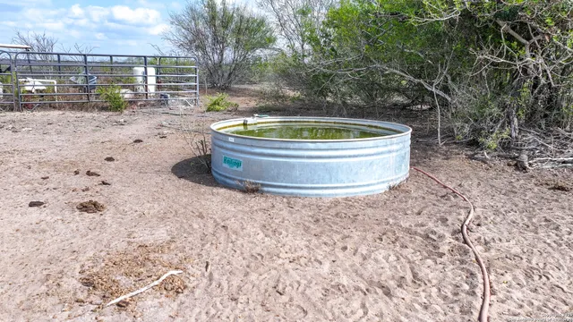 a view of dirt field with trees in the background