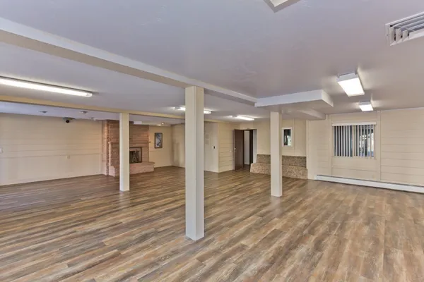 a view of a big room with wooden floor and windows