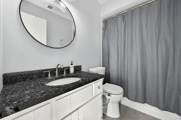 a bathroom with a granite countertop sink and a mirror