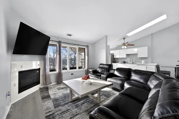 a living room with furniture a fireplace and a flat screen tv