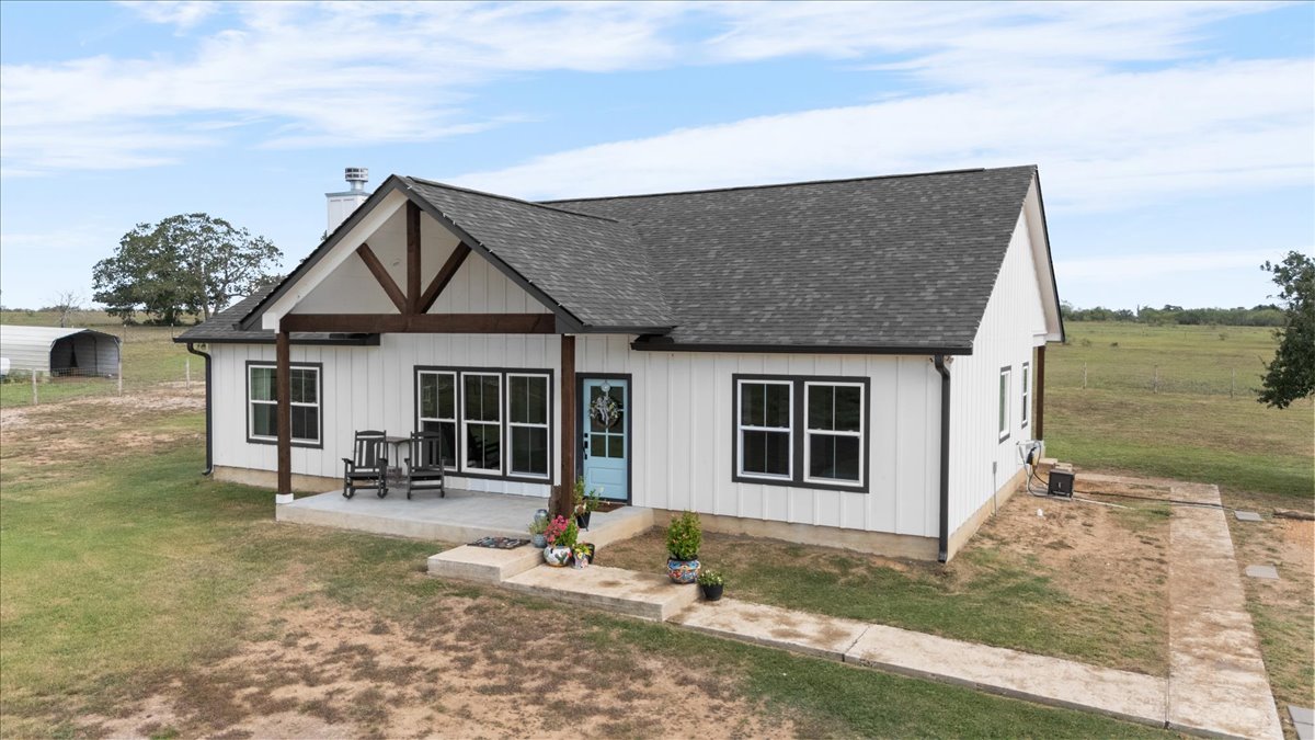 3389 Sparta Field Road Waelder, TX 78959 - Photo 23 of 40 Back of house with a shingled roof, a chimney, a patio, and a yard