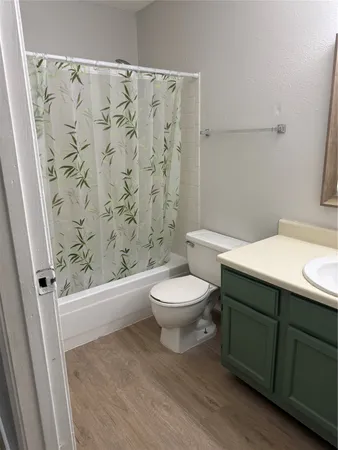 a view of an empty room with chandelier fan