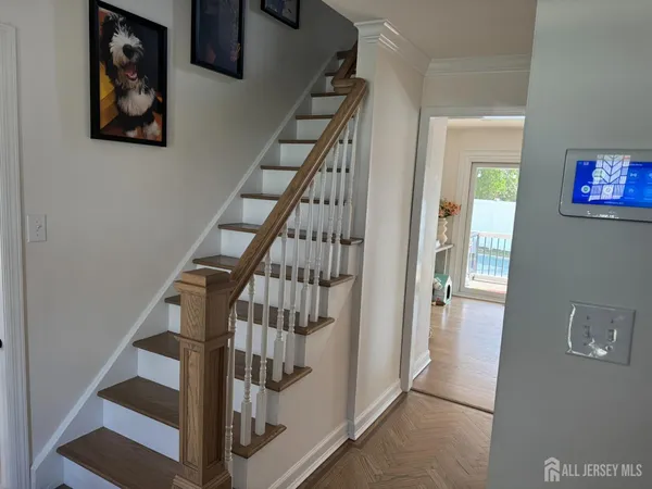 a view of staircase with lots of frames and a painting on the wall