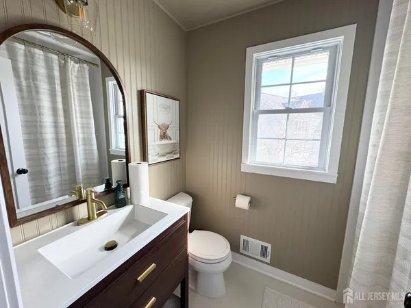 a bathroom with a sink a toilet and a mirror