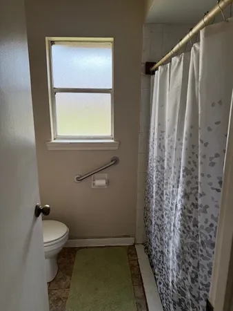 a bathroom with a toilet and a shower