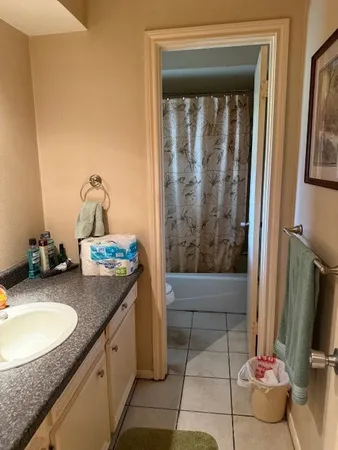 a bathroom with a granite countertop sink a mirror and shower