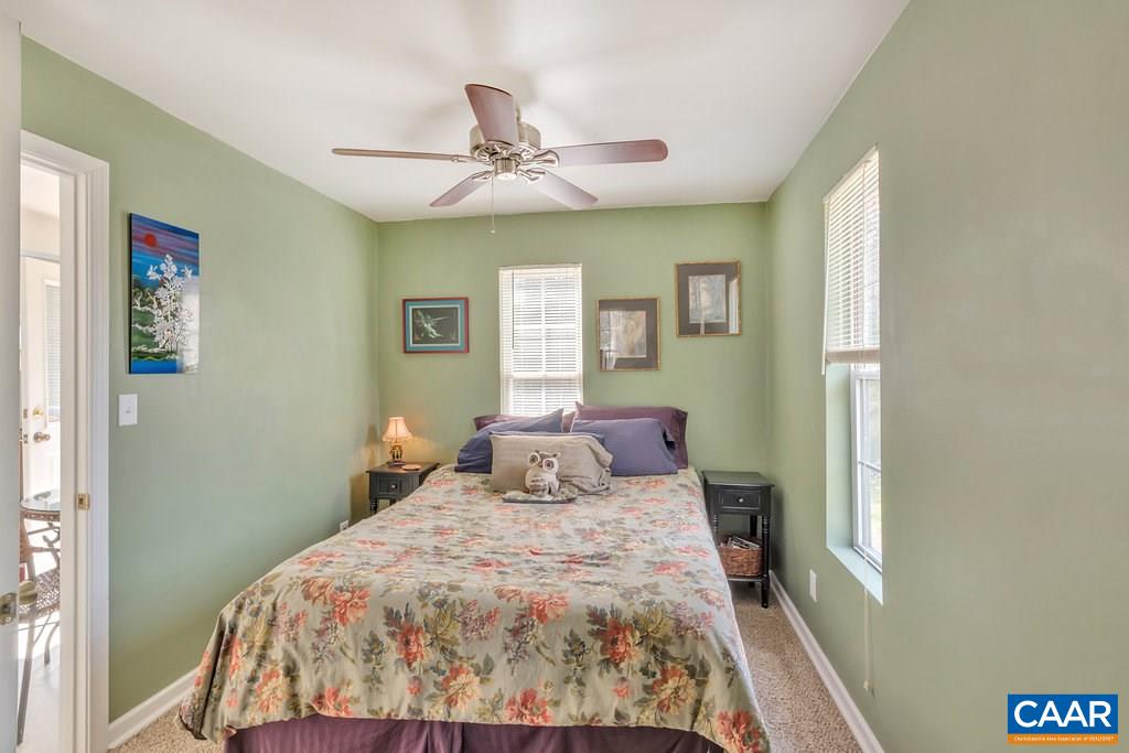 782 West Daffodil Road Ruckersville, VA 22968 - Photo 9 of 18 a bedroom with a large bed and a chandelier