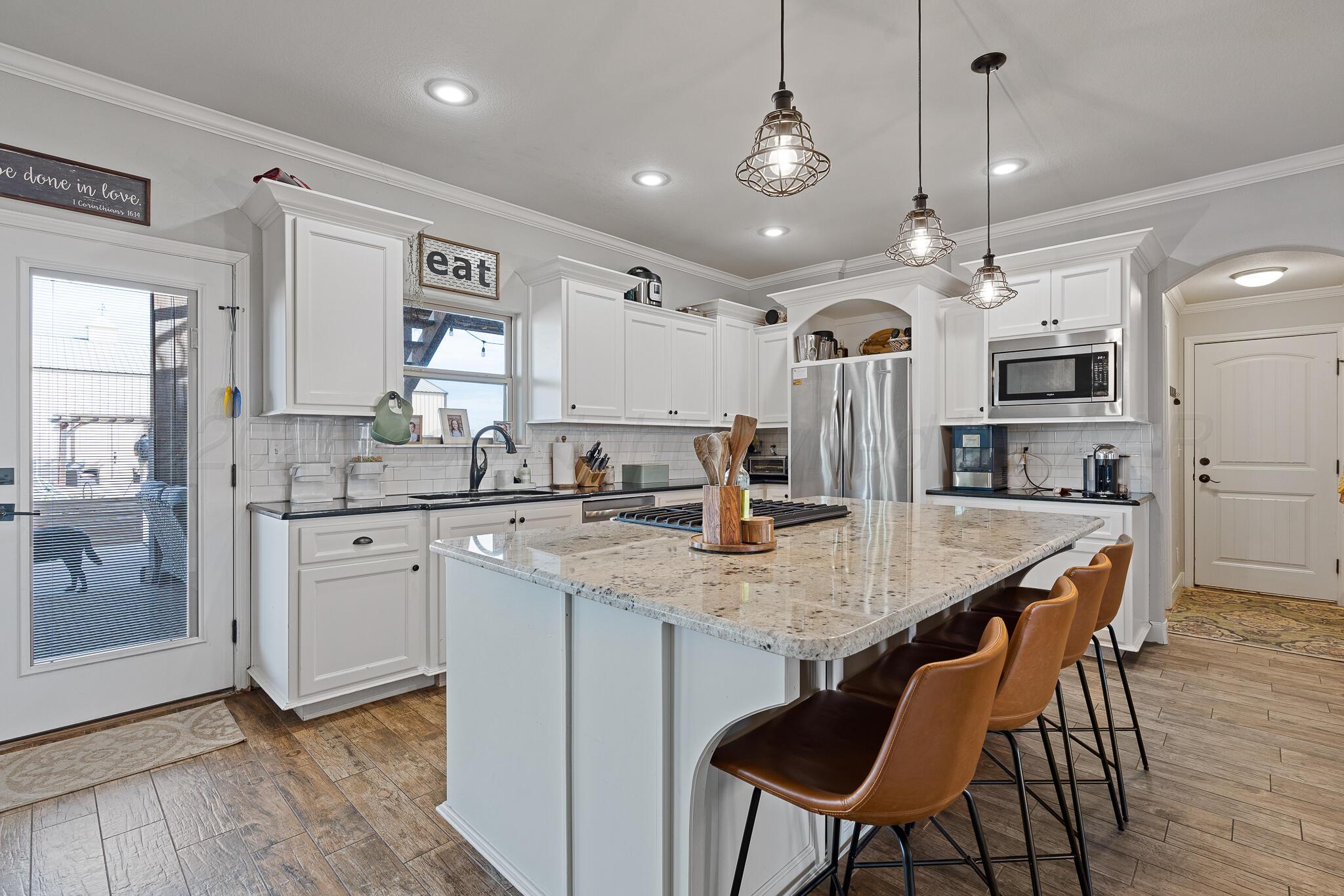 19000 Spirit Loop Amarillo, TX 79119 - Photo 15 of 86 a open kitchen with stainless steel appliances kitchen island granite countertop a kitchen island a stove a table and chairs in it