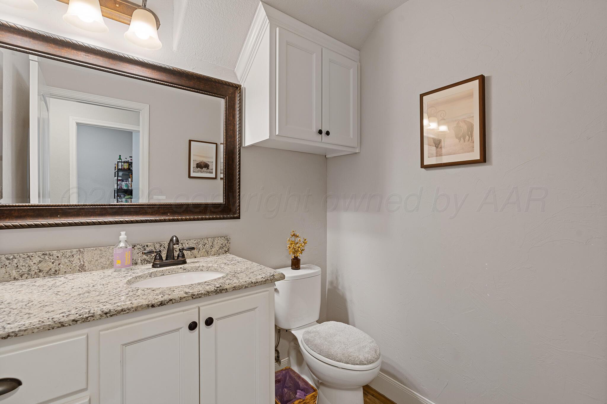 19000 Spirit Loop Amarillo, TX 79119 - Photo 24 of 86 a bathroom with a granite countertop toilet a sink and mirror