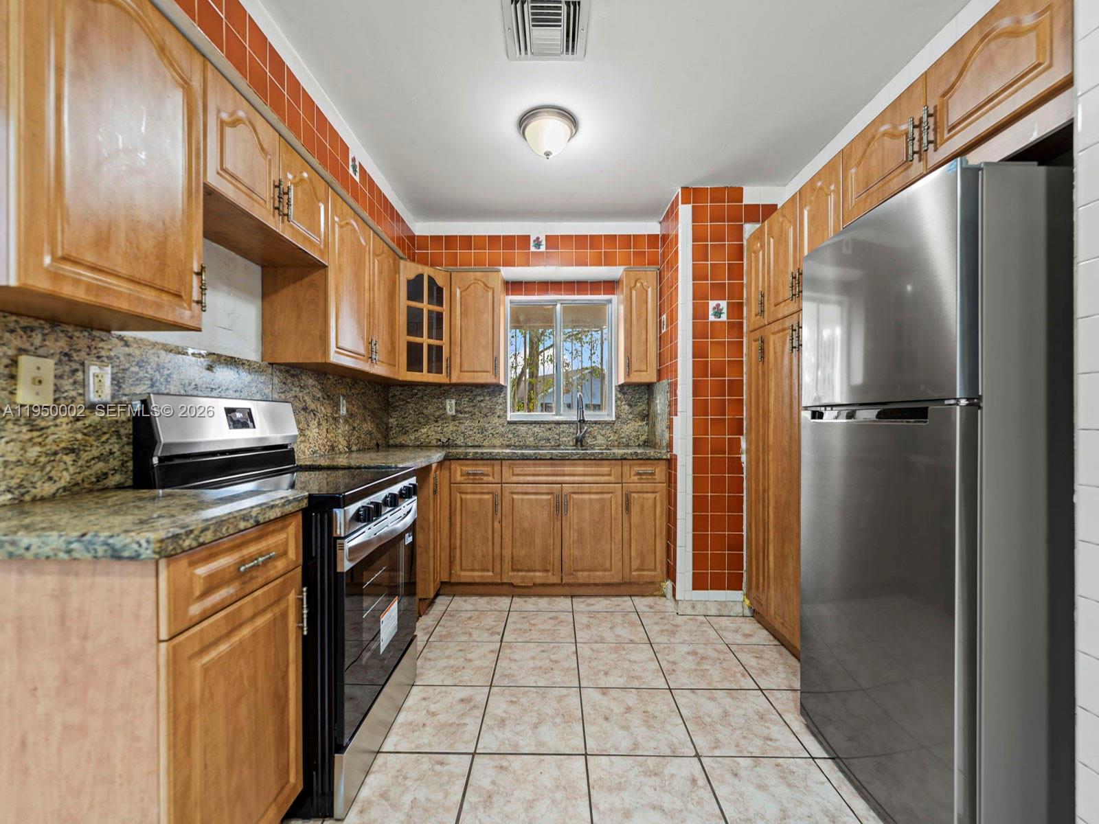 11075 Southwest 221st Terrace Miami, FL 33170 - Photo 2 of 31 a kitchen with stainless steel appliances granite countertop a stove a sink and a refrigerator