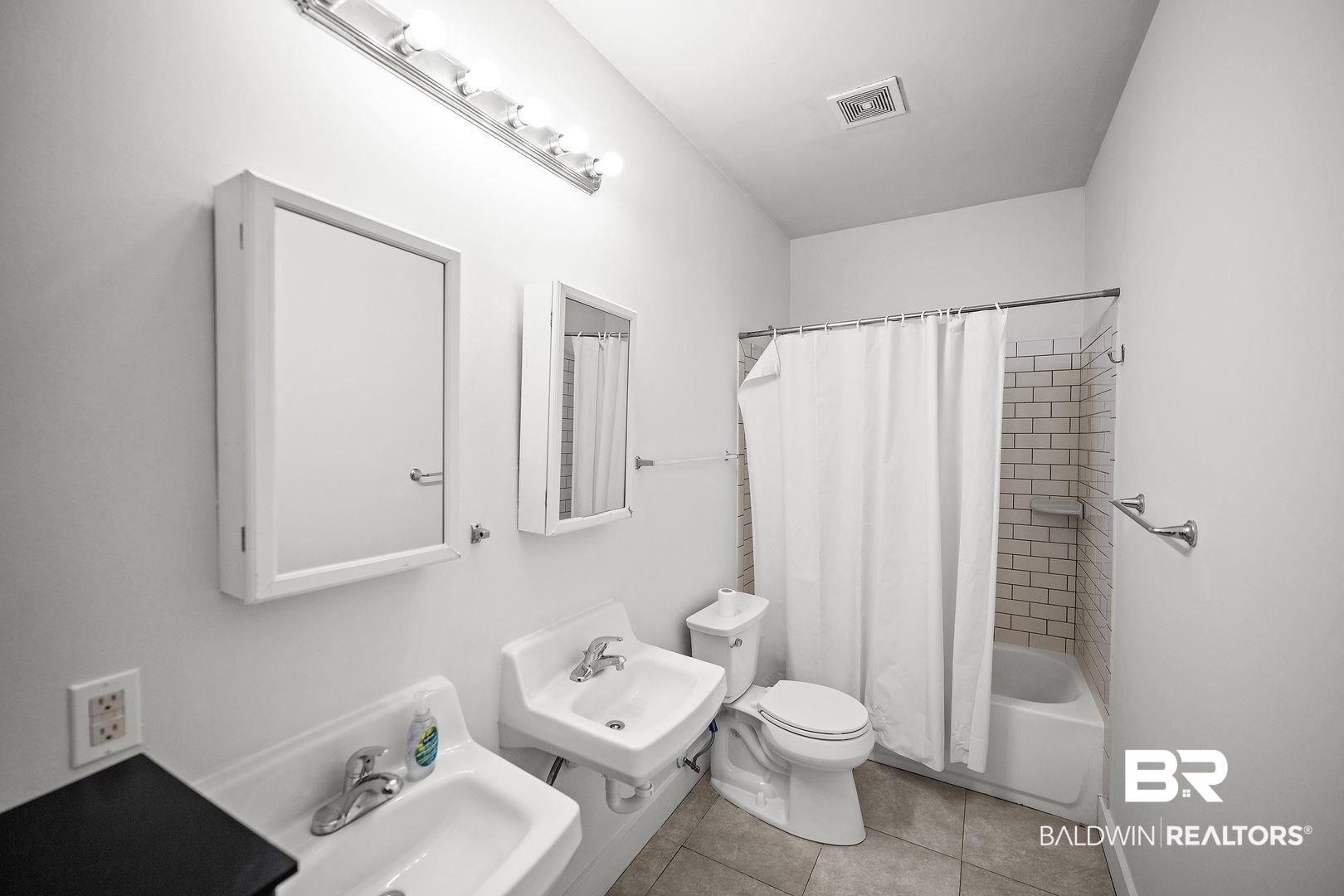 635 East Azalea Avenue Foley, AL 36535 - Photo 4 of 18 Bathroom featuring dual pedestal sinks, white subway tile shower surround, and tiled flooring