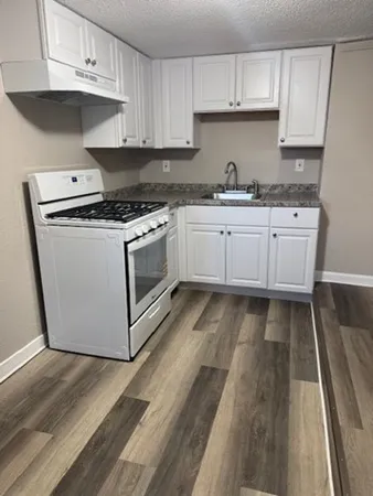 a stove top oven sitting inside of a kitchen