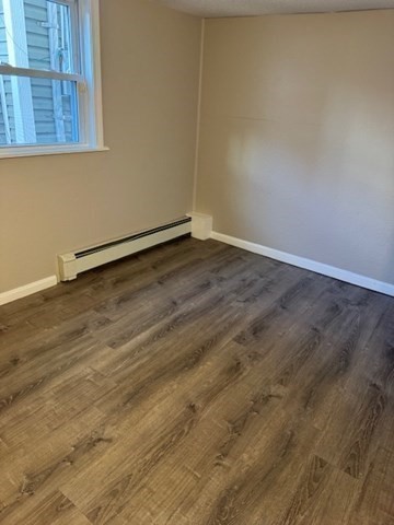 153 Union Street, Unit 1B Lawrence, MA 01841 - Photo 7 of 10 an empty room with wooden floor and windows