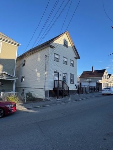 153 Union Street, Unit 1B Lawrence, MA 01841 - Photo 10 of 10 a front view of a house with a yard and garage