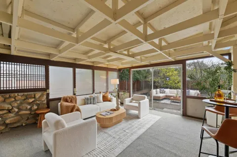 a living room with furniture and a floor to ceiling window