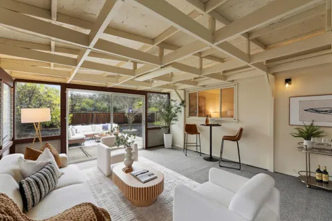 a living room with furniture and a floor to ceiling window